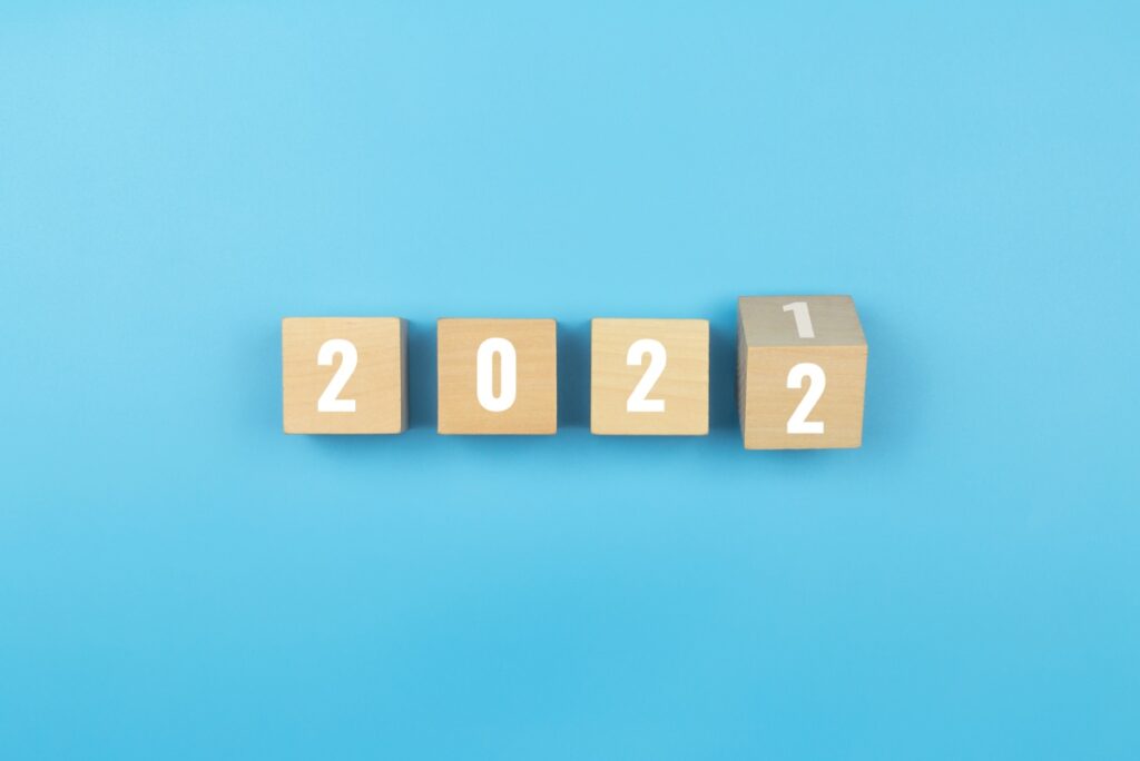 Happy new year. Wooden cube with the number 2021 to 2022 on blue background