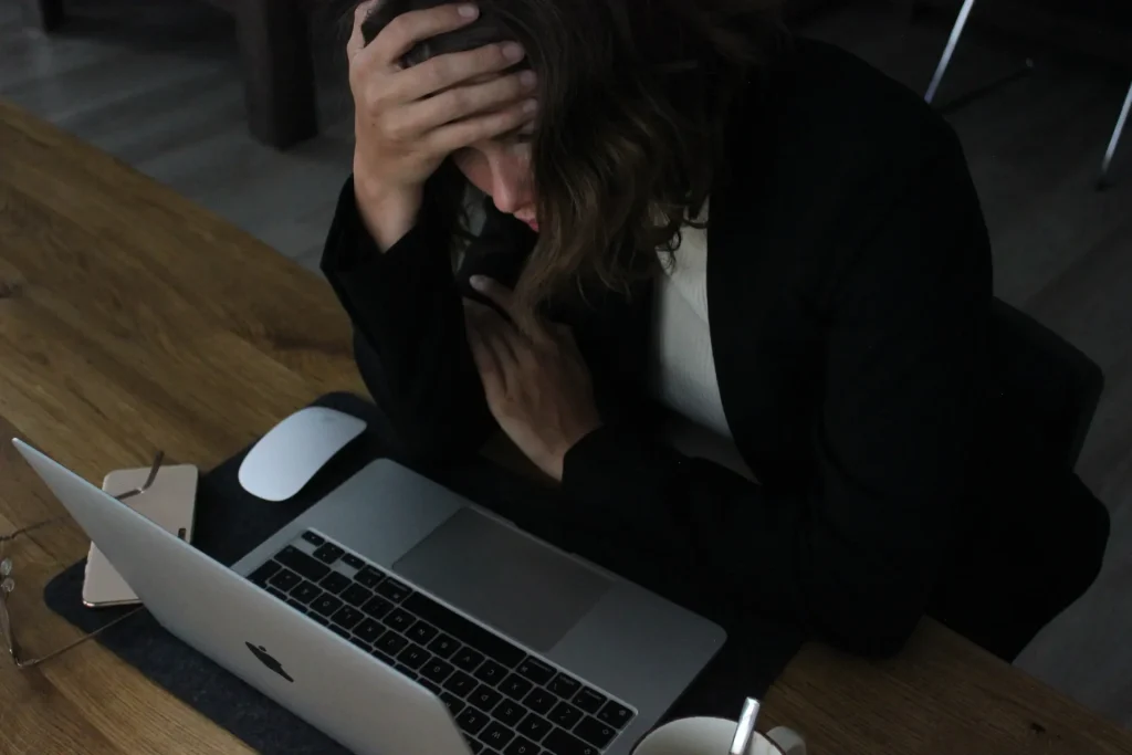 Woman sitting at desk appearing stressed